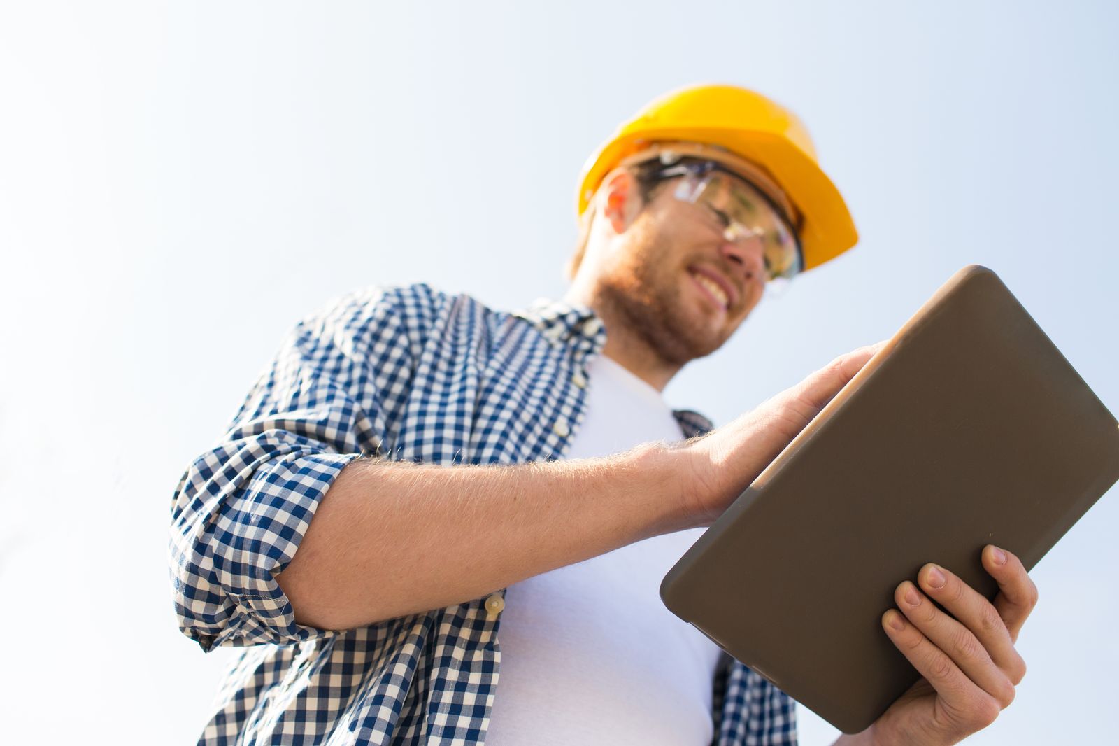 Placeholder for Randy's crew photo: a contractor in a hard hat checking a tablet on site