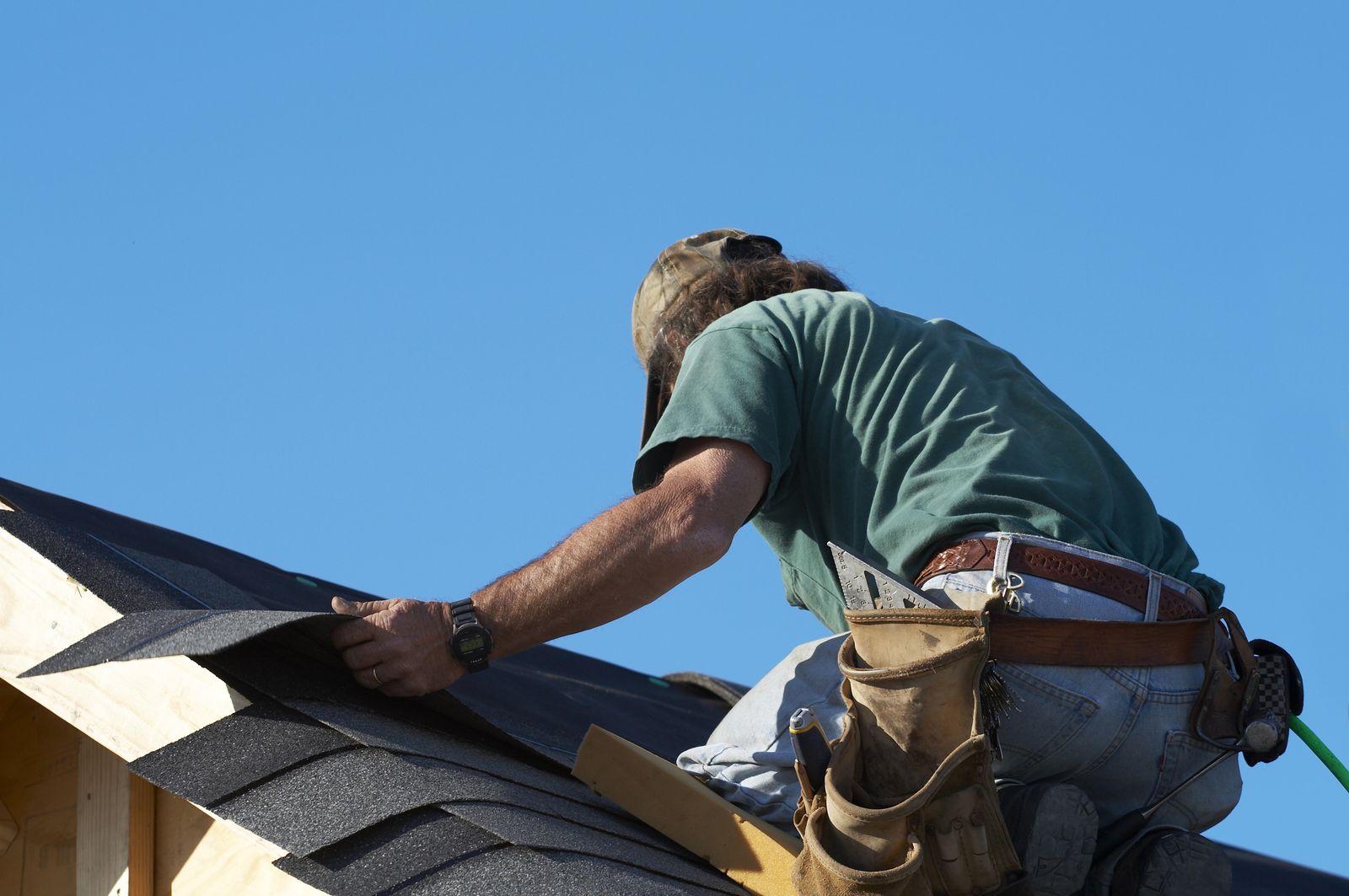 Placeholder for Randy's job photo: a roofer laying architectural shingles at the ridge of a house